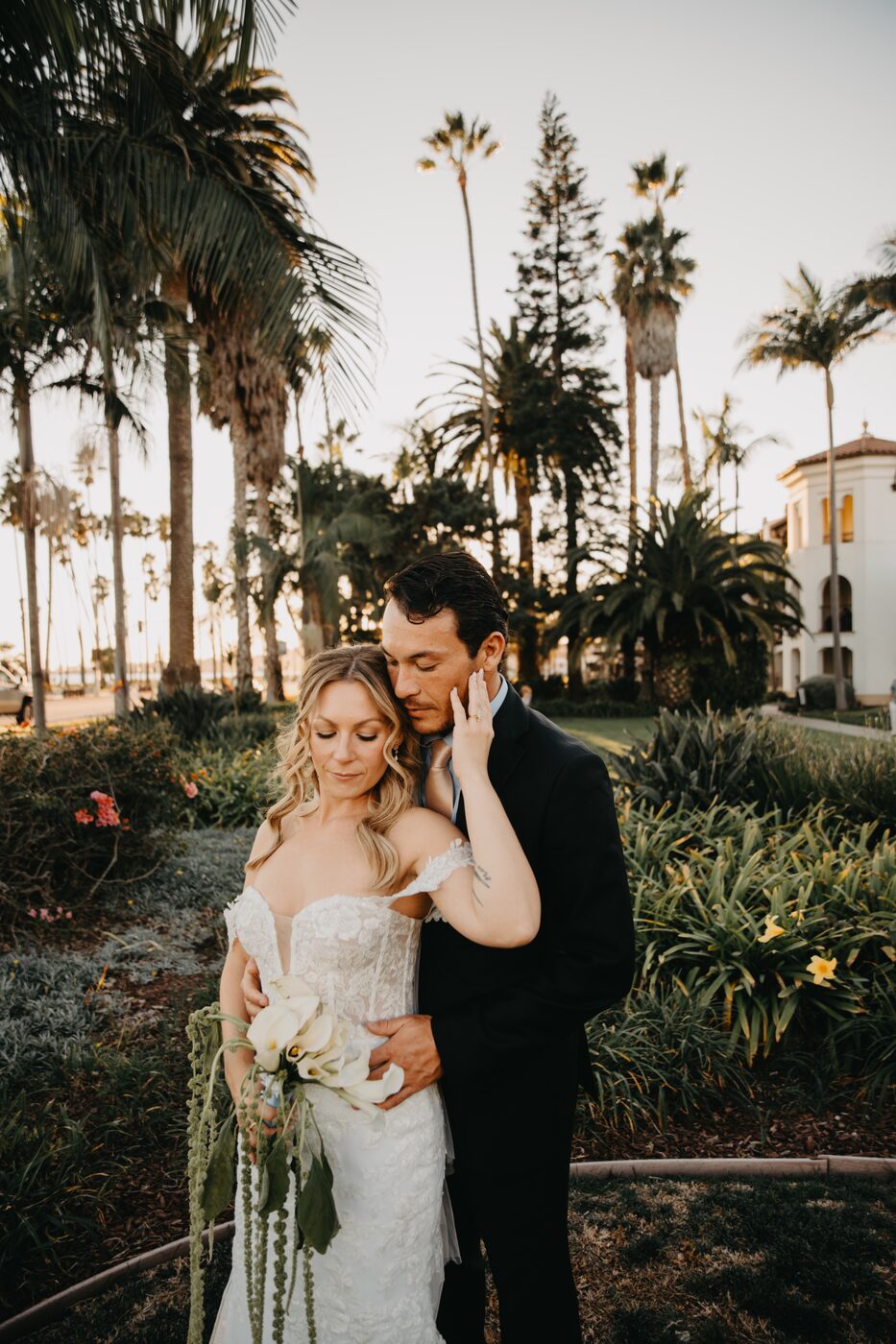 A couple embracing among the palms at sunset outside the Mar Monte Hotel